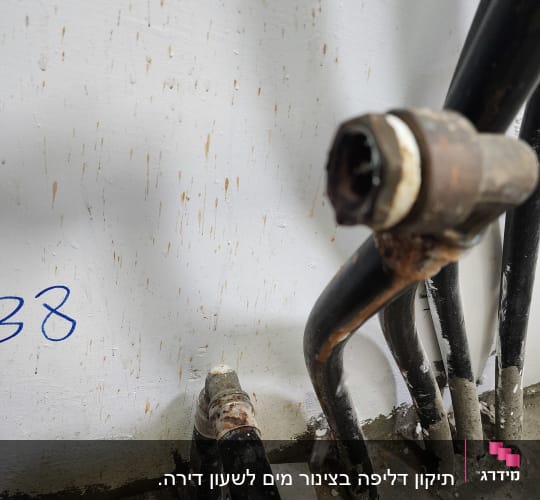 צינורות מתכת חלודים על קיר לבן